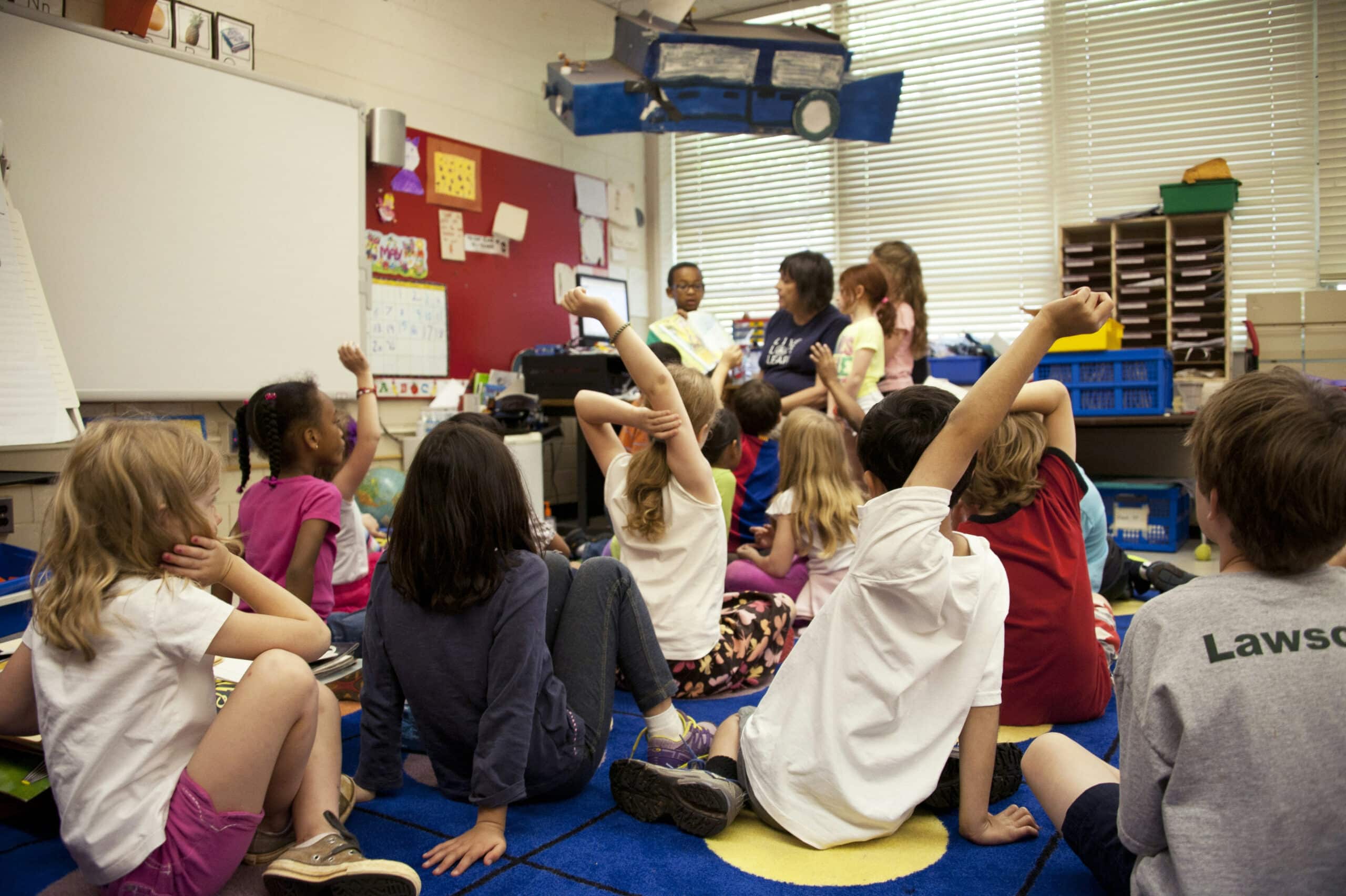 students on the floor learning from teacher