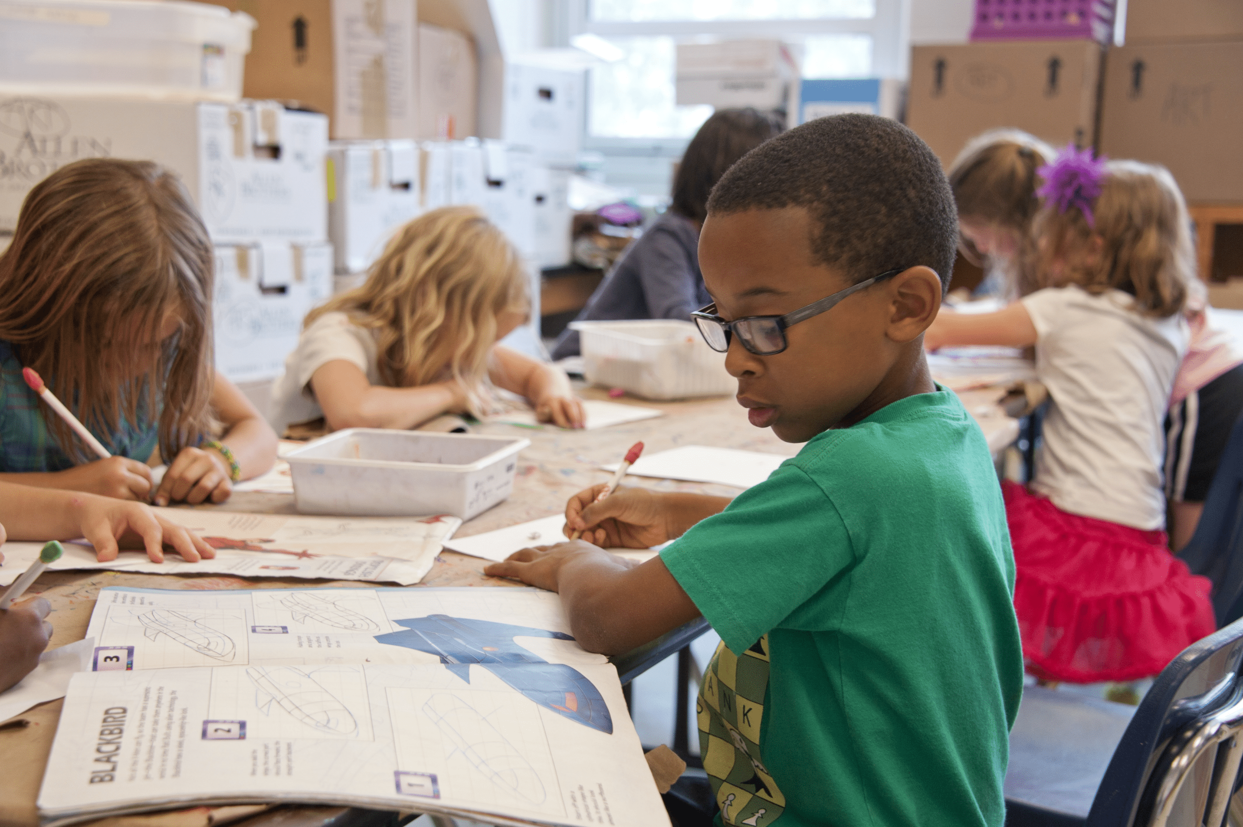 students sitting at a table drawing